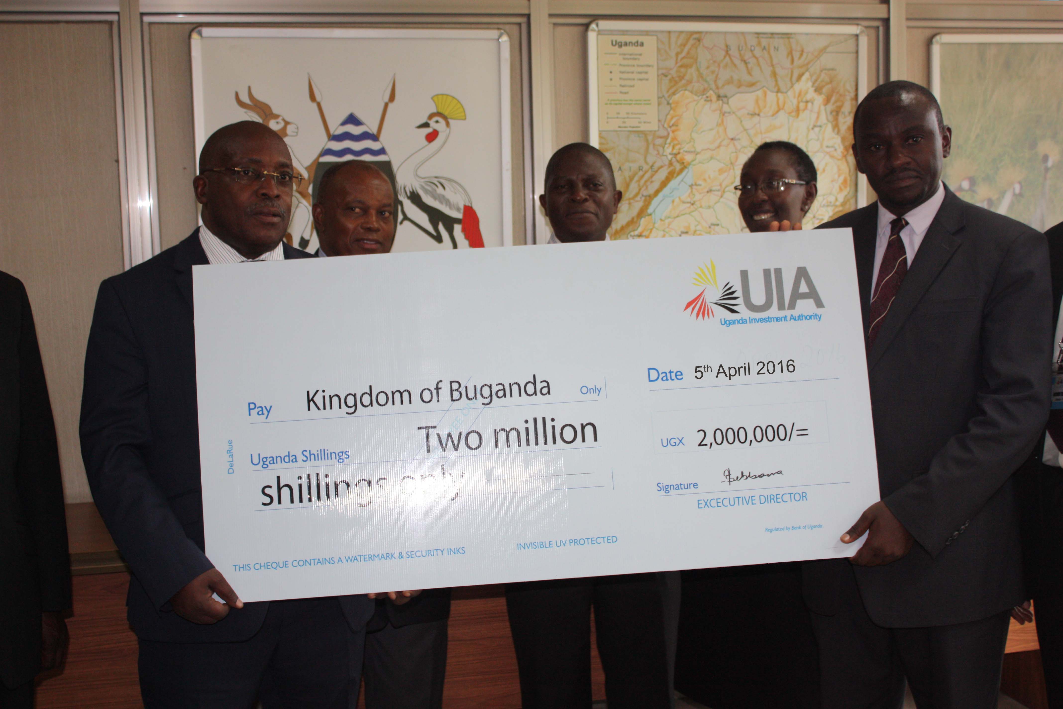 Eng Dr Sebbowa handing over the dummy cheque to Ow'ekitiibwa Henry Sekabembe, the Minister of Sports in the Kingdom of Buganda.