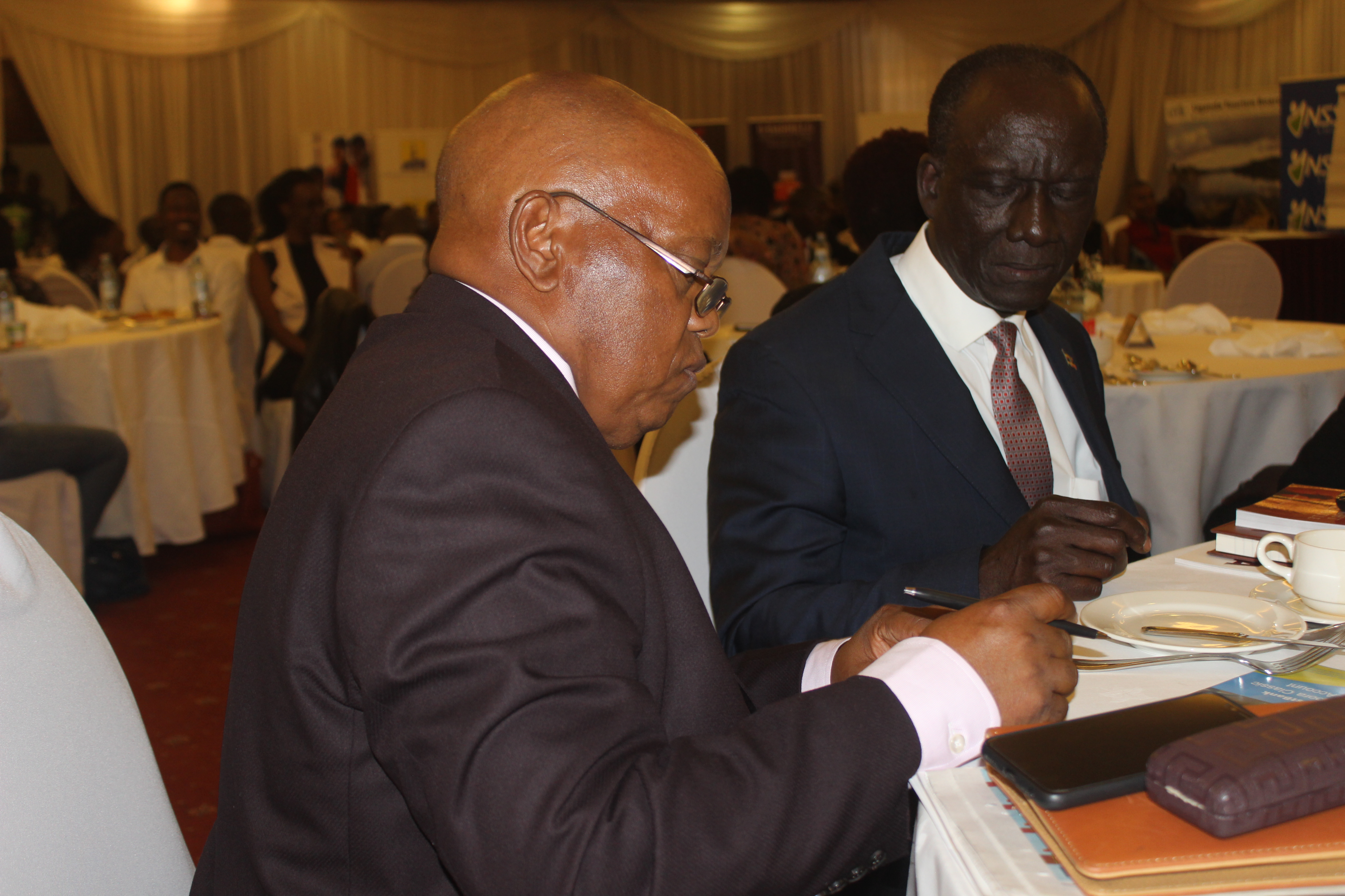 UIA Acting Director General Lawrence Byensi sharing notes with Uganda's Ambassador to Washington Mr. Mull Katende at the Diaspora social networking dinner at Serena hotel.